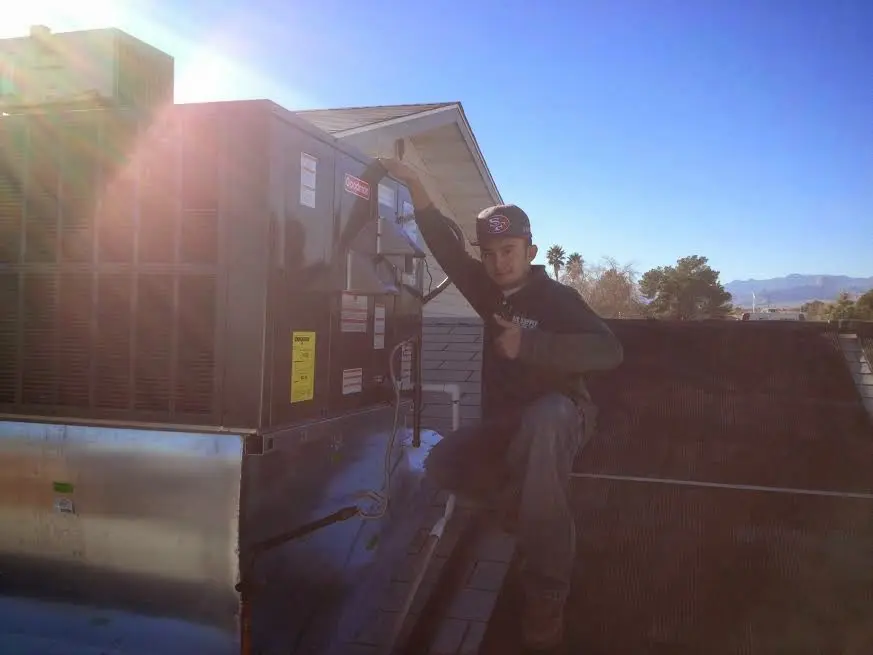 HVAC technician performing AC Tune-Up on a rooftop unit in Valencia West